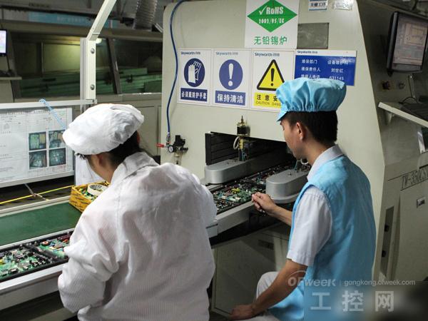 据酷开工作人员介绍,这样一条SMT生产线,包含全自动印刷机、超高速贴片机、高速多功能贴片机、热风回流焊机和光学自动检测仪等重要设备,价值达800多万,而在酷开,这样的生产线已有28条。 主板机芯完成和检测——灵巧手工打造 基础电路板生产完成后,紧接着,进入酷开的机芯生产车间,该车间主要就是在SMT贴片后的电路进行自动设备还不能完成的大元器件的插件。在这个环节中,工作人员都会戴上防静电手腕进行手工作业,插件工序主要是完成SMT自动化作业无法完成的任务,就是将各种大大小小不